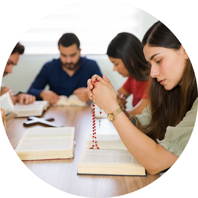 Four people sit at a table, deeply focused on reading books and holding prayer beads, embodying the serene spirit of intercultural church services.